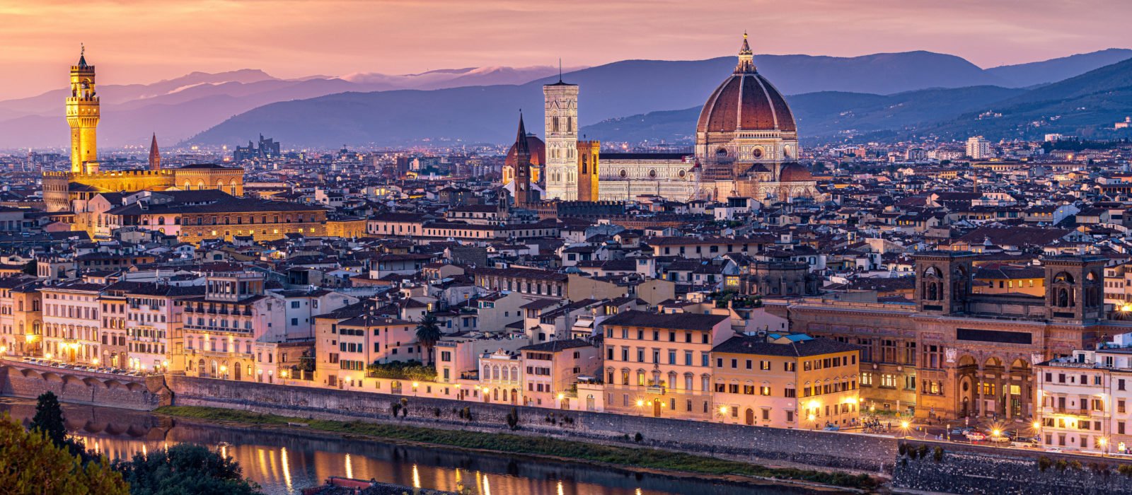 Sunset over the city of Florence - view from hilltop a=outside the city showing the grand dome of the cathedral, city spires and rolling hills in the background