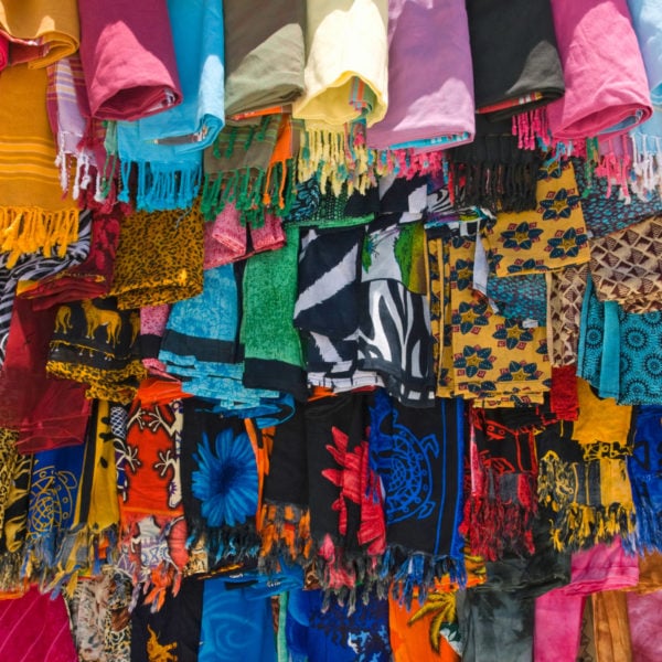 Brightly coloured shawls and scarfs hanging from a stall