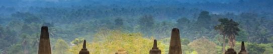 Openwork stupas of Borobudur Temple against a backdrop of lush jungle