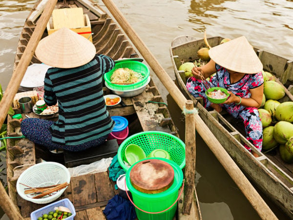 Vietnamese woman selling Pho - noodle soup on floating market