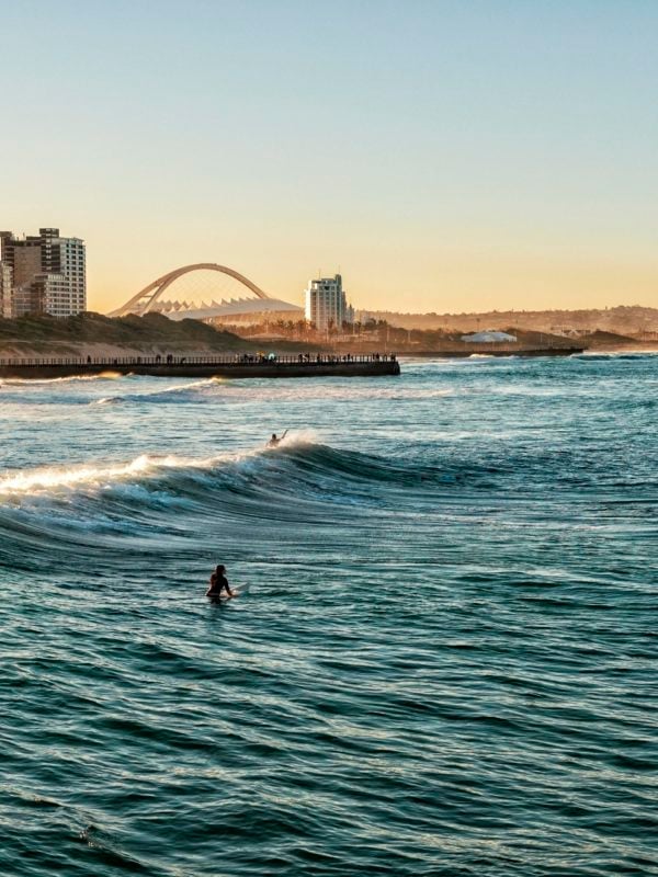 Surfers Enjoying the Waves During Sunset in Durban, South Africa