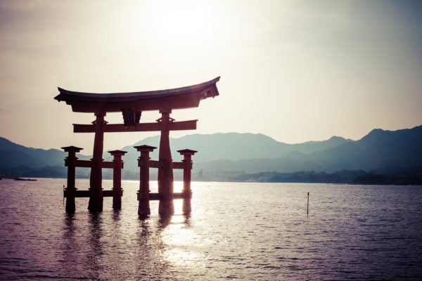 Miyajima, Famous big Shinto torii standing in the water in a bay , with misty mountains in the background in Hiroshima, Japan