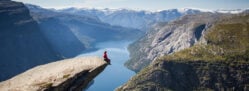 man sitting on trolltunga in norway