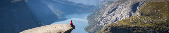 man sitting on trolltunga in norway