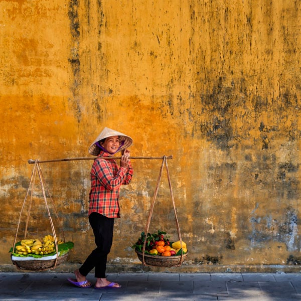 Vietnamese woman selling tropical fruits, old town in Hoi An city, Vietnam