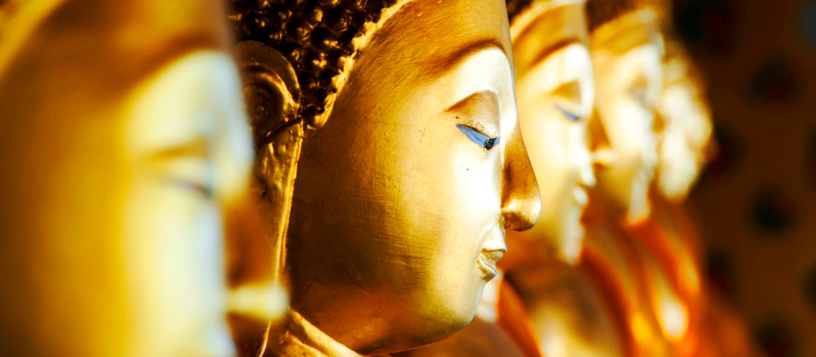 Row of golden Buddhas at Wat Arun, Bangkok, Thailand.